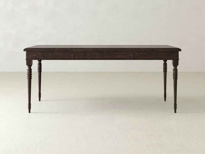 The Audrey Desk - Tobacco by James+James features a close-up of dark brown wood with a coarse, textured grain pattern. Variations in the wood's surface create a mix of lighter and darker areas, giving it a rich, natural look. Small imperfections and lines add character to its rustic appearance.