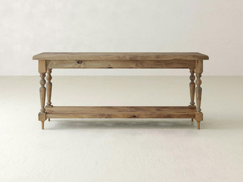 The Ella Sofa Table - Harvest Wheat by James+James is a rustic wooden console table featuring a rectangular top and bottom shelf. With its turned legs and natural wood finish, it exudes a charming vintage and farmhouse appearance.