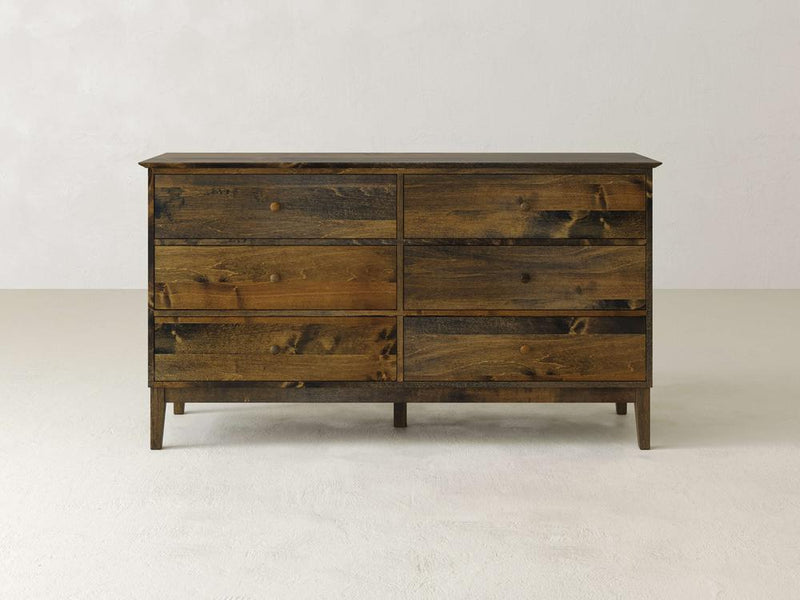 The Bennett 6 Drawer Dresser by James & James stands against a white background, highlighting its rustic design in solid maple wood with dark-stained panels, subtle grain patterns, and simple tapered legs.