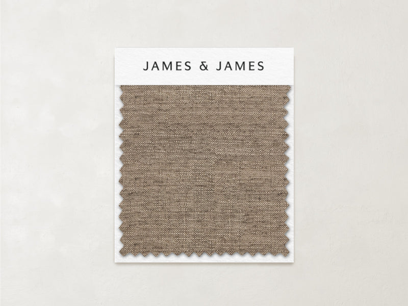 A rectangular Sand - Linen Swatch with zigzag edges is attached to a card labeled "James+James." The light brown linen showcases breathable texture and timeless elegance against a neutral background.
