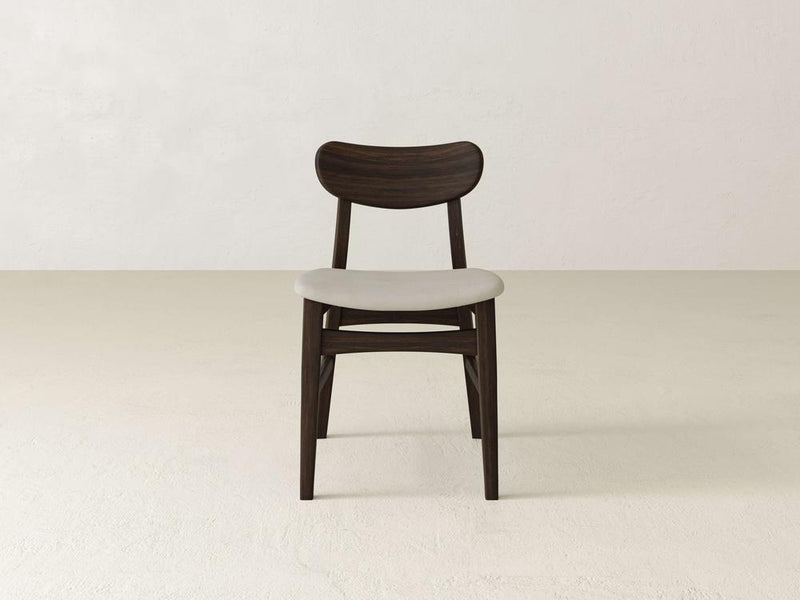 A modern chair with a dark wooden frame and a light gray cushioned seat is centered against a plain off-white background. The design is minimalist and sleek, emphasizing clean lines and simplicity.