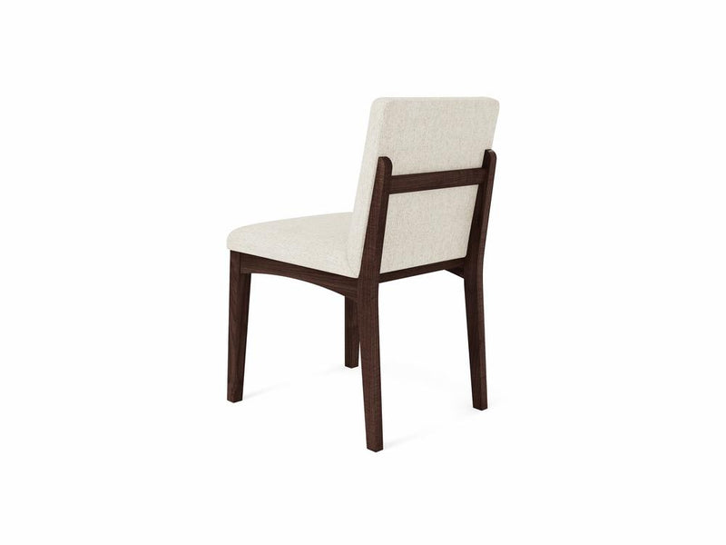 The Klein Dining Chair by James & James showcases a minimalist design with a white upholstered seat and backrest, paired with a dark frame and slender maple wooden legs, viewed from the rear.