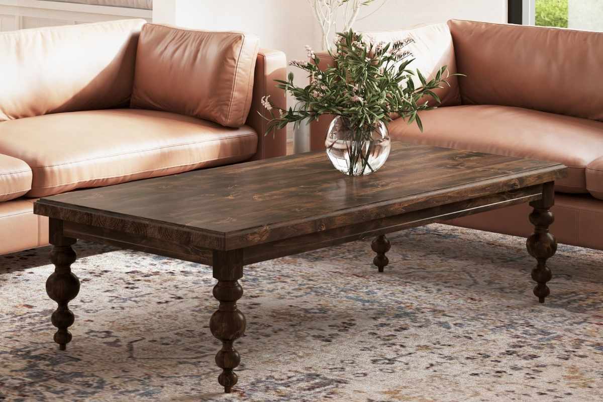 Solid wood coffee table styled in a modern living room with leather sofas and neutral decor, illustrating interior design principles.  