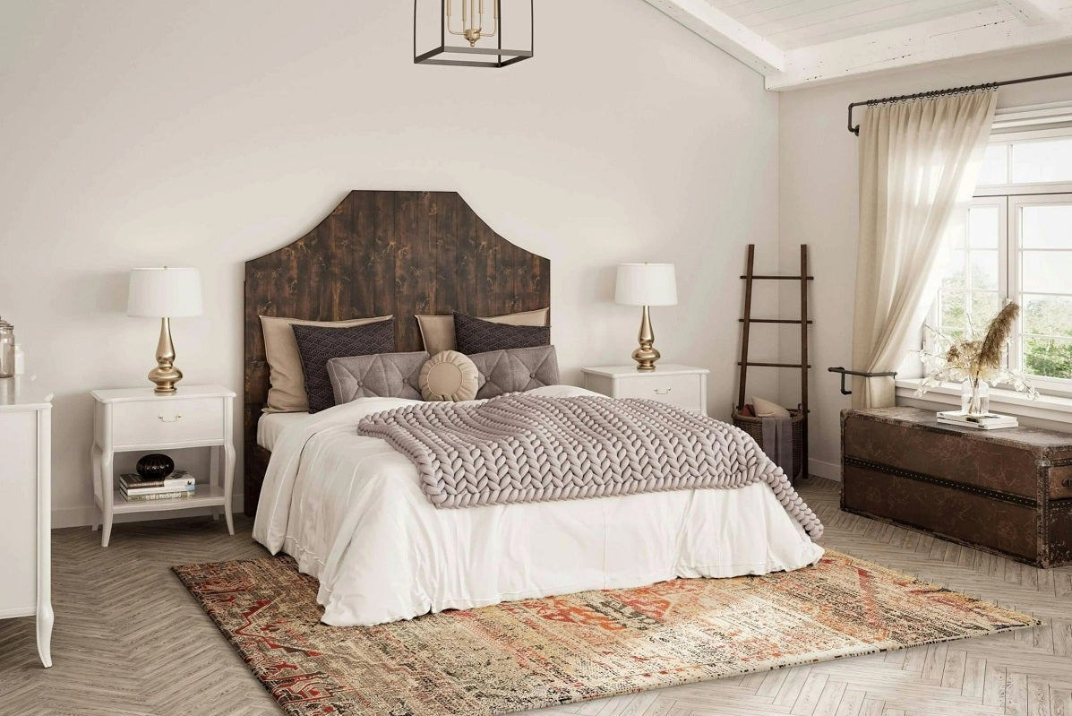 Bedroom with a solid wood bed frame and styled bedding, illustrating size and design considerations when choosing between twin, full, and queen beds.  
