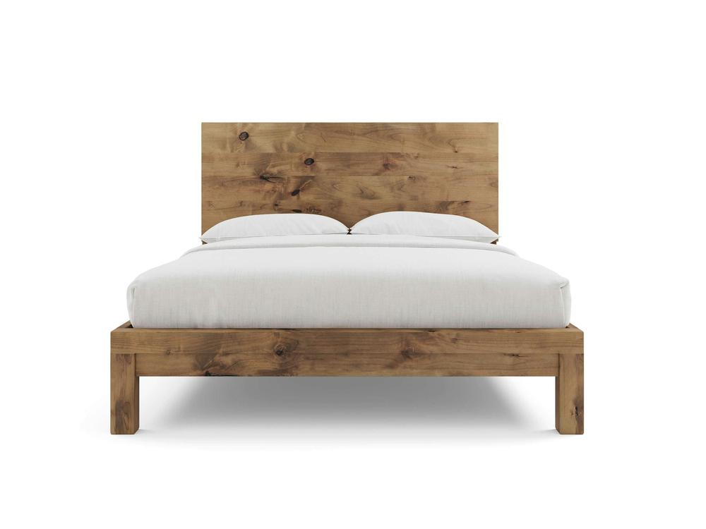 The Sawyer Bed - Harvest Wheat on Alder by James+James features a matching headboard and natural wood grain finish. Shown from the front with white bedding and two pillows, set against a plain white background.