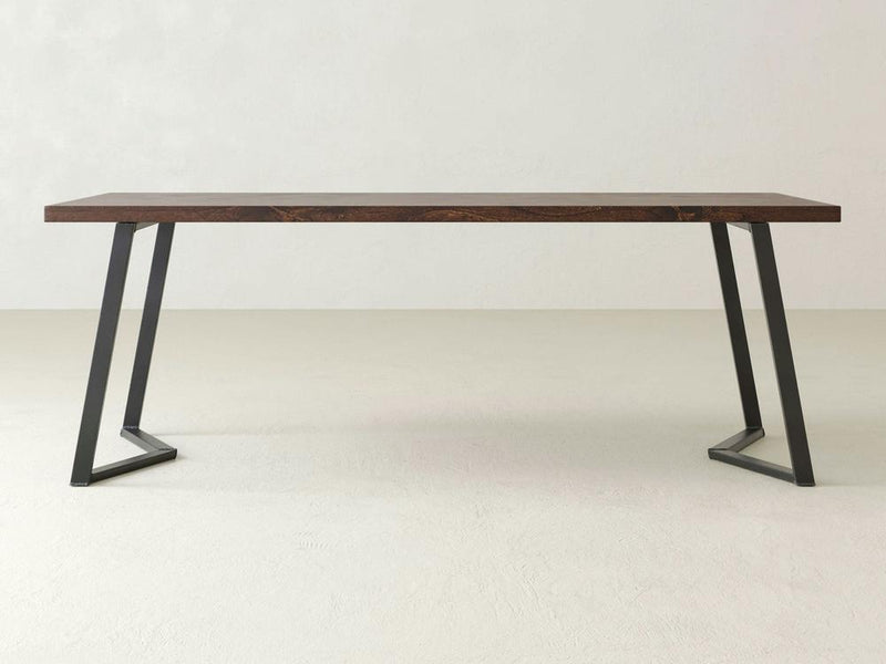 A close-up view of the Arkwright Desk - Tobacco by James+James, showcasing the rich, textured grain patterns and natural variations in color. The desk features deep brown tones with some lighter areas, highlighting the beauty of the natural wood.