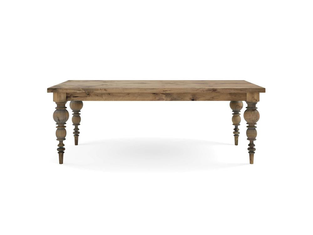 A Bailey Dining Table - Harvest Wheat by James+James, featuring a rectangular wooden top and elaborately carved, spindle-style legs. The wood boasts a natural, rustic finish that highlights its grain and offers a slightly weathered appearance. The table is beautifully set against a plain white background.