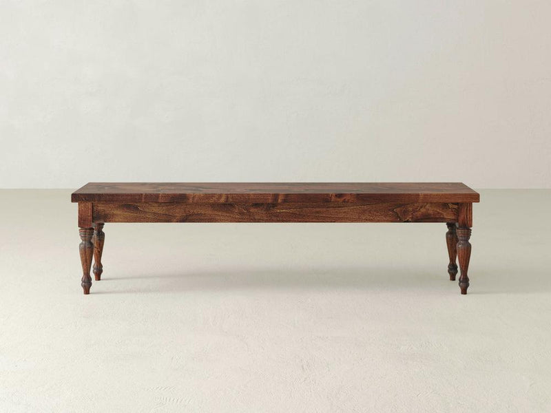 The Chateau Bench - Tuscany by James & James features a simple, rustic design with a smooth rectangular seat and four intricately carved legs on a light background.