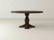 The Heirloom Round Dining Table - Tobacco by James+James features a single central pedestal leg that branches out into four feet. This dark brown wooden table boasts a smooth finish and an elegant, classic design, making it perfect for dining or decor.