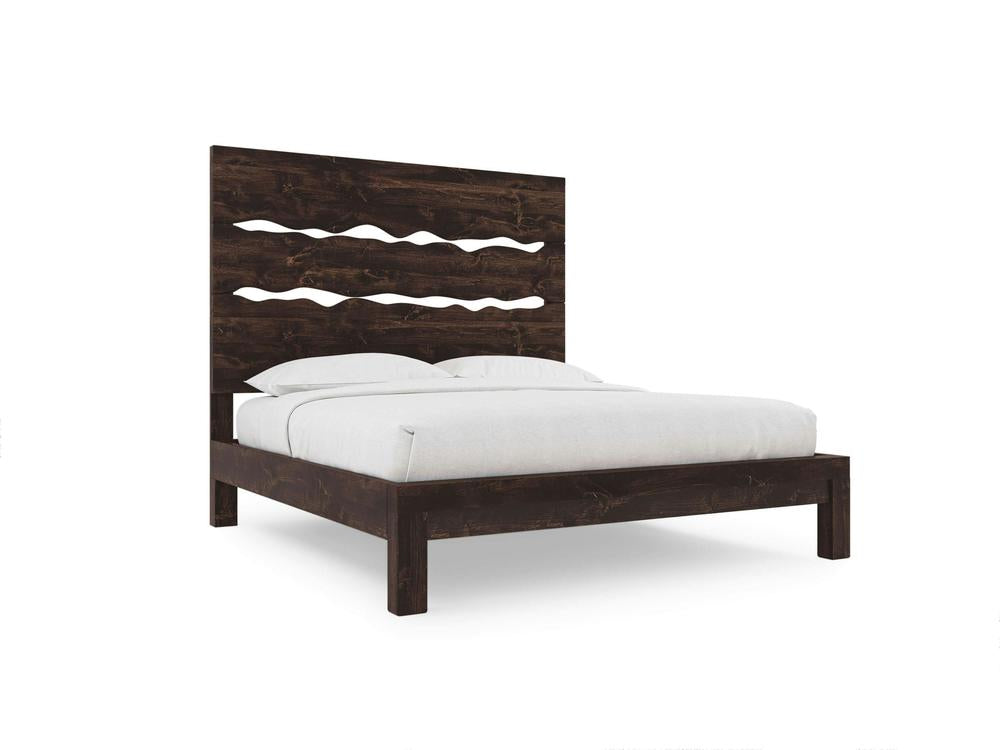 The James+James Live Edge Bed in Tobacco on Alder is a modern dark wood bed with a high headboard featuring wavy cut-out designs, shown with white bedding and pillows against a plain white background.