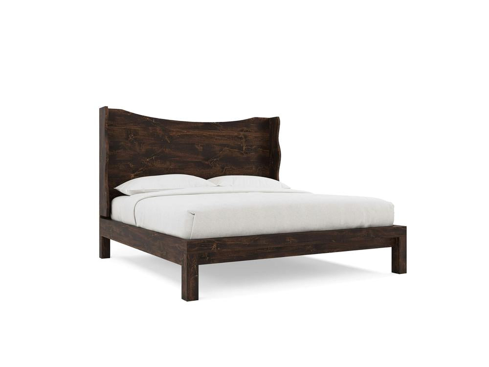 The Harlow Bed by James+James features a modern wooden frame in Tobacco on Alder, with a curved headboard and a neatly made bed with white sheets and pillows, set against a plain white background.
