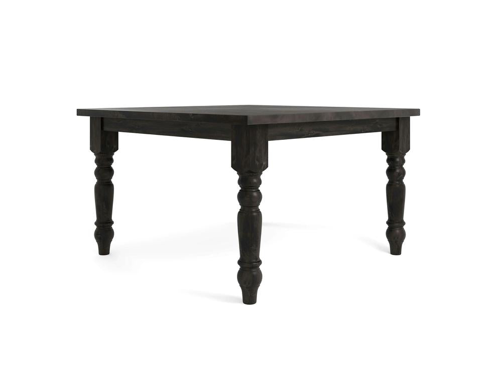 The Baluster Square Dining Table - Charred Ember by James+James is a black wooden dining table with a rectangular top and intricately carved legs. The sturdy legs feature a decorative, traditional design, adding an elegant touch to the otherwise minimalist and functional table.