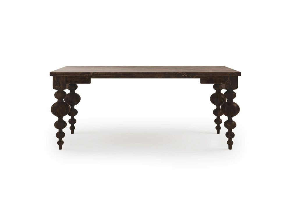 The Olivia Desk - Tobacco by James+James features a dark wooden rectangular top and ornately carved, turned legs. The design of the legs showcases a series of rounded and tapered sections, giving the desk a vintage or antique look. This elegant piece stands alone on a white background.