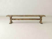 The James+James Trestle Bench in Harvest Wheat on Alder features a simple, sturdy design and rustic wood finish, shown against a plain off-white background.