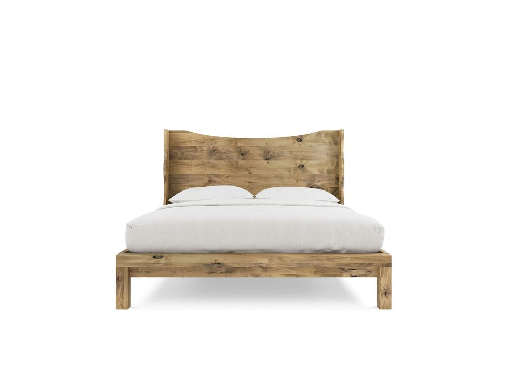 The Harlow Bed by James+James, crafted from alder in a Harvest Wheat finish, features a curved headboard and is styled with white bedding and two pillows, set against a plain white background.