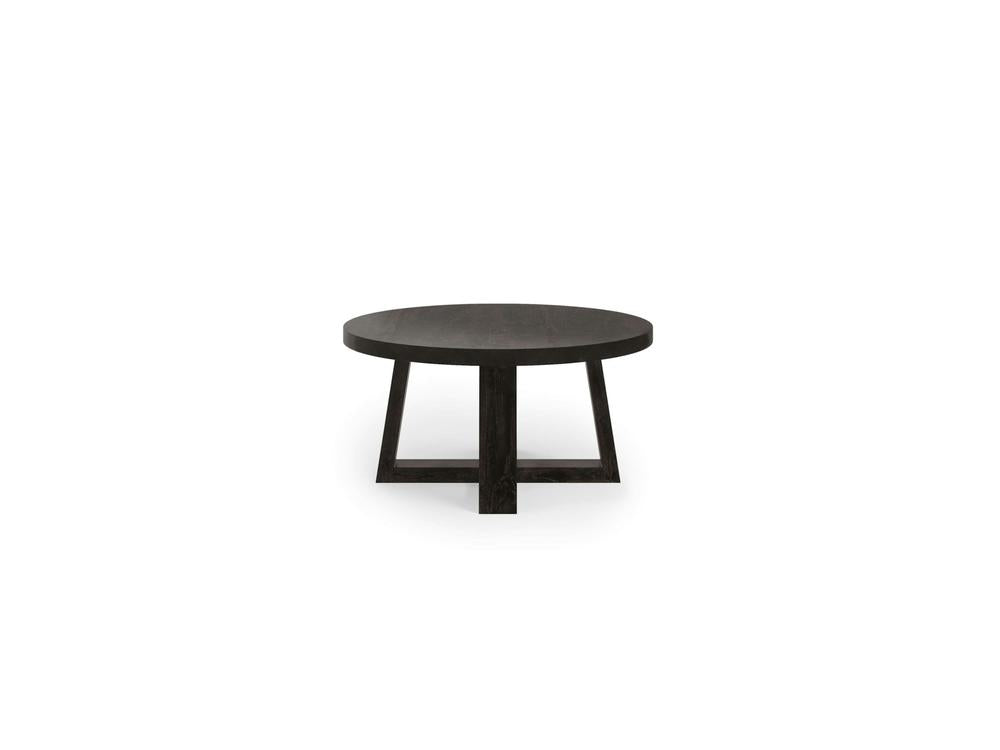 The Rae Coffee Table - Charred Ember by James+James is a modern, round coffee table with a sleek design. It features a dark wooden top and a unique triangular-legged base, all finished in matching dark tones. The table is set against a plain white background.