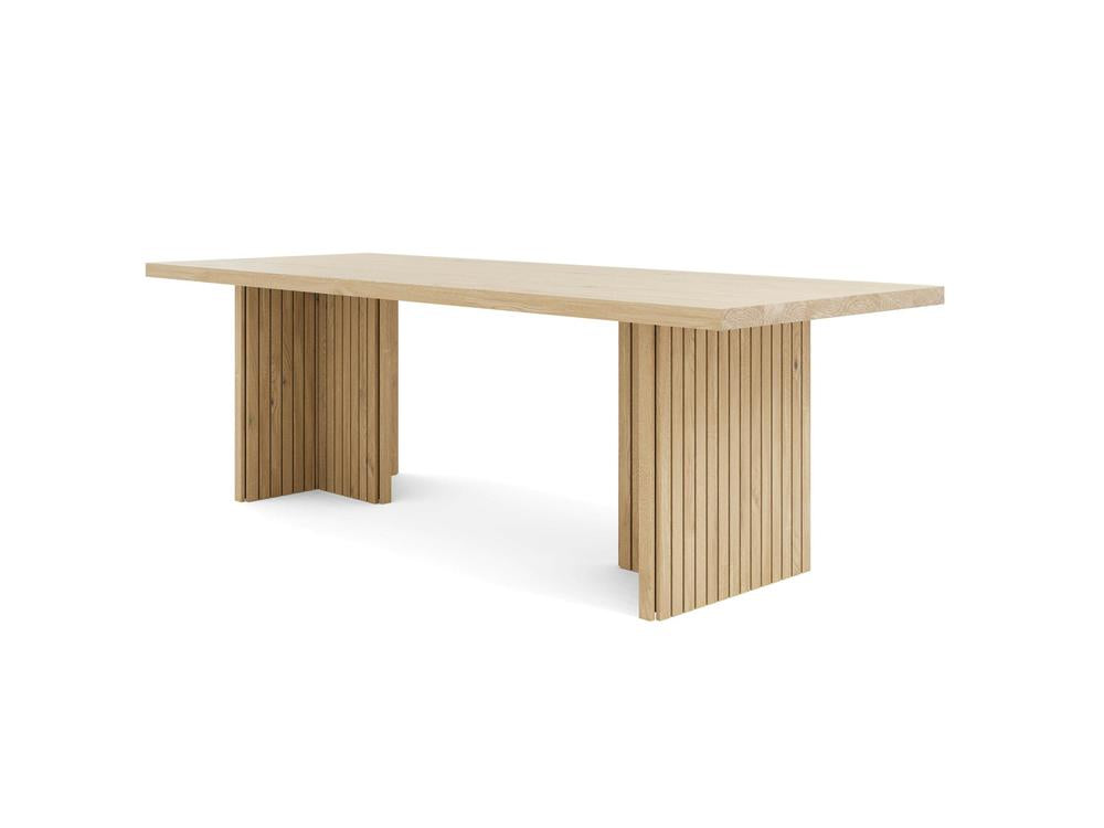 The Francesca Dining Table - Satin by James+James is a rectangular wooden dining table with a minimalist design. The tabletop is smooth and flat, supported by two wide, slatted, vertical legs on each end. The light-colored wood gives a modern and elegant touch to the furniture piece.