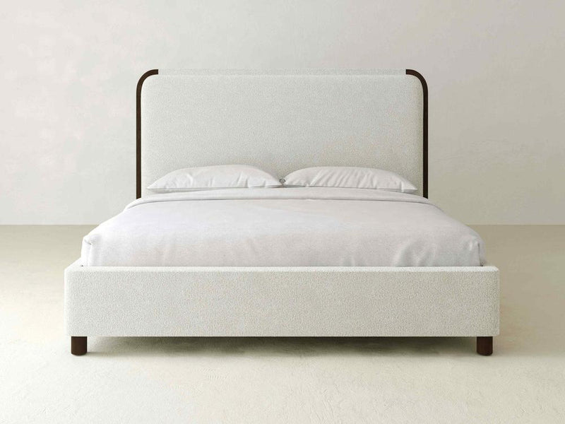 The Sloane Bed – Boucle by James & James epitomizes modern elegance with its light gray upholstered headboard. It includes two neatly arranged white pillows, complementing a neutral-toned room with a minimalist vibe.