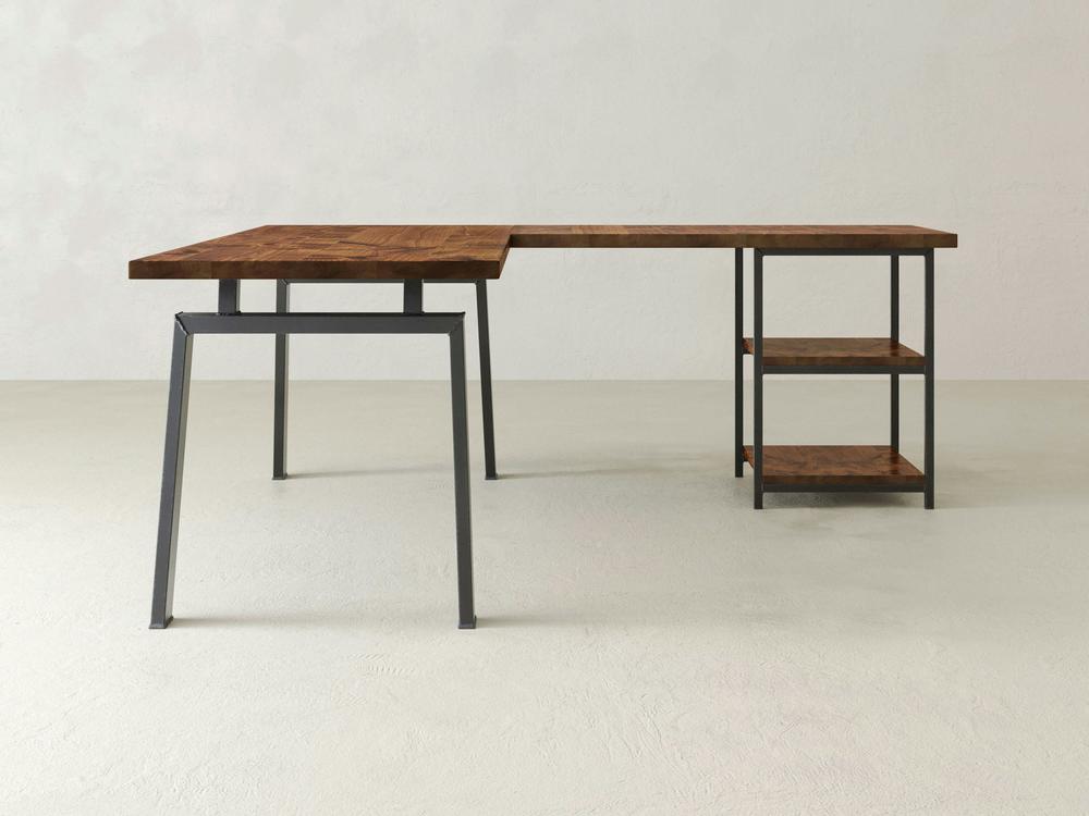 The James & James Fulton Corner Desk combines industrial elegance with a minimalist wooden top and sleek metal frame, featuring two shelves for a chic look. It perfectly complements light grey floors and walls, offering customization options to fit any space.