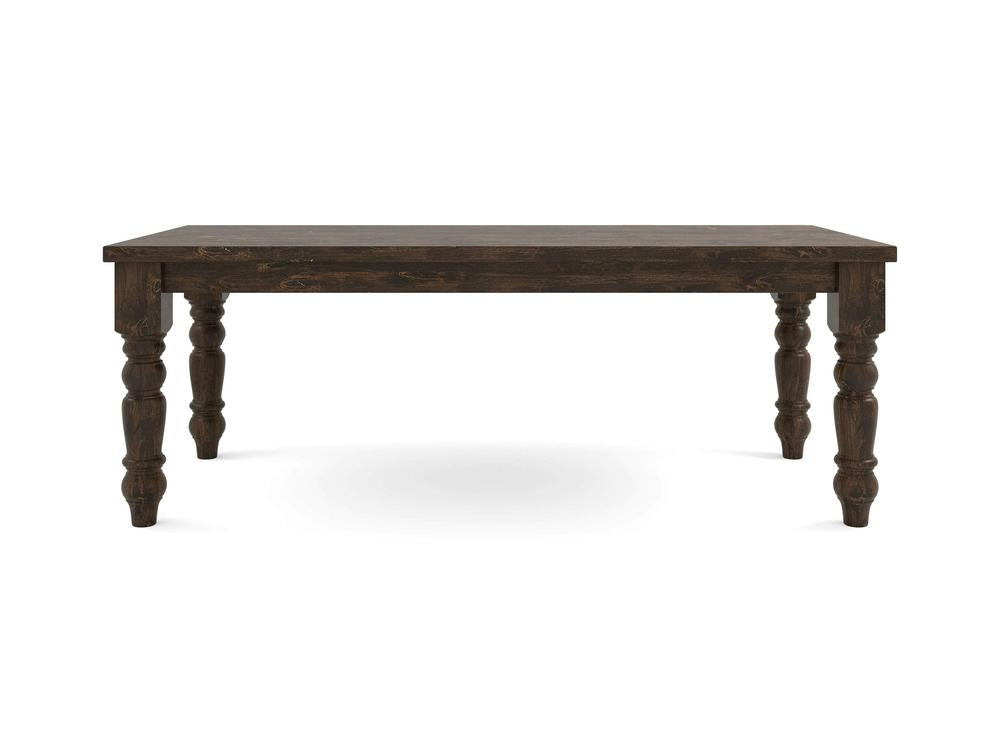 The Baluster Dining Table - Tobacco by James+James is a rectangular wooden dining table featuring a dark brown finish. It boasts a solid top and four intricately carved, thick legs that provide a sturdy, traditional look. The surface is characterized by its distressed wood texture.