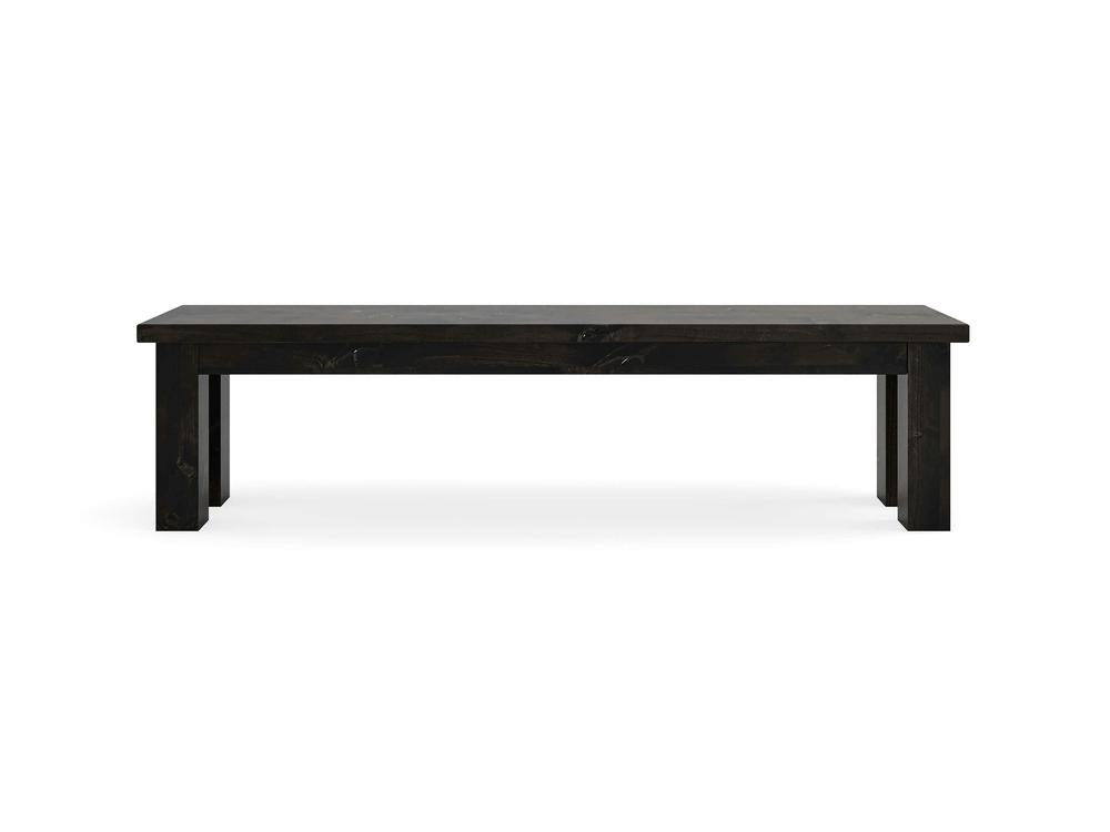 The James+James Farmhouse Bench - Charred Ember on Alder is a sturdy rectangular bench with thick legs and a simple design, crafted from dark wood and photographed against a plain white background.