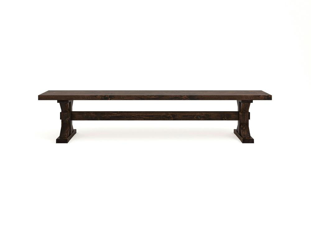 The James+James Trestle Bench in Tobacco on Alder features a rustic dark wood design, flat top, sturdy rectangular legs, and a support beam. Photographed against a plain white background.