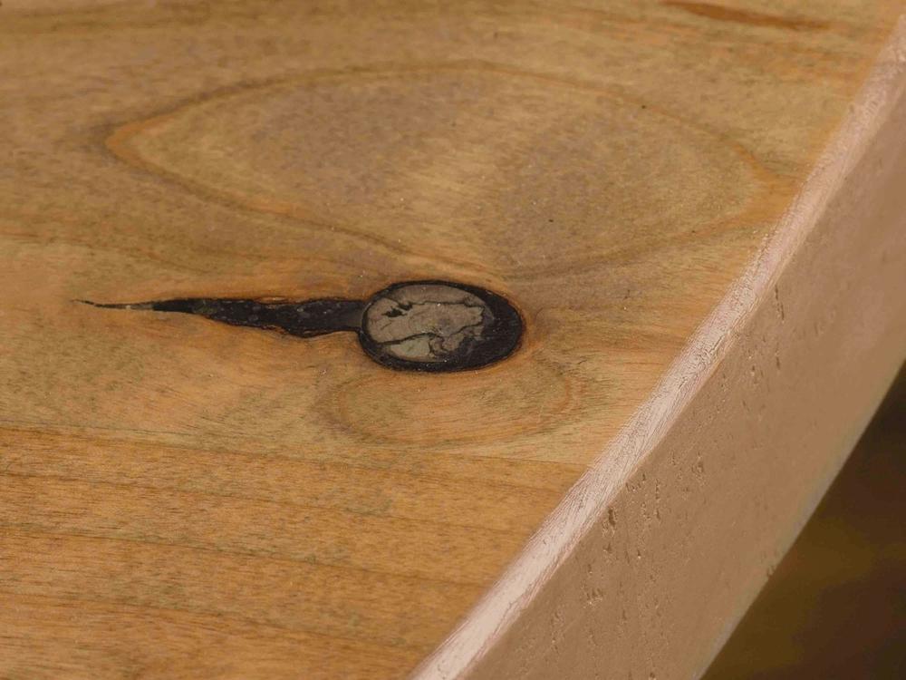 Close-up of the surface of the Violet Round Dining Table - Harvest Wheat by James+James, showcasing a natural wood grain pattern with a dark knot near the center. The wood has a light, smooth finish and the edge is slightly rounded. The knot features a small crack extending from its left side.