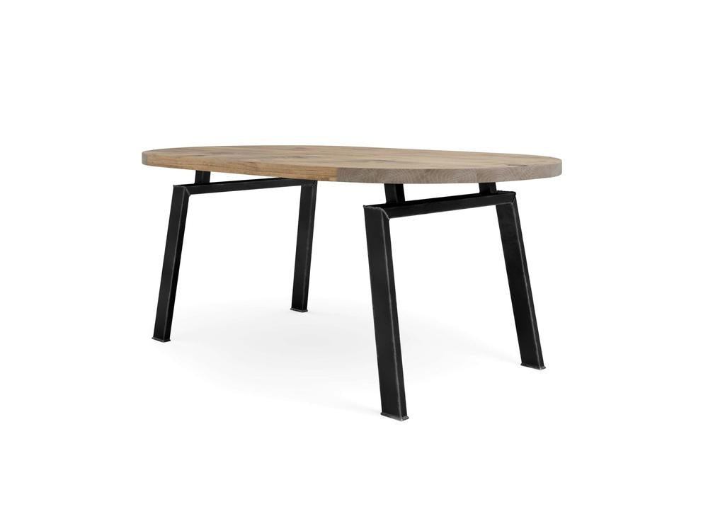 The Fulton Oval Dining Table - Harvest Wheat by James+James features a modern oval-shaped wooden tabletop with a natural harvest wheat finish. It stands on four black, angled metal legs connected to a horizontal support bar underneath the tabletop. The minimalist design gives it a contemporary appearance.