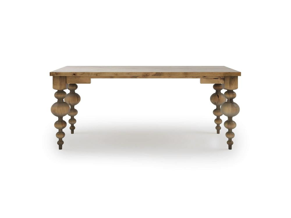 The Olivia Desk by James+James, featuring a rectangular top and decorative turned legs with a natural wood finish in Harvest Wheat. The legs showcase a series of rounded, bulbous shapes stacked vertically, giving the desk a classic and elegant appearance. Set against a plain white background, this piece is both functional and stylish.