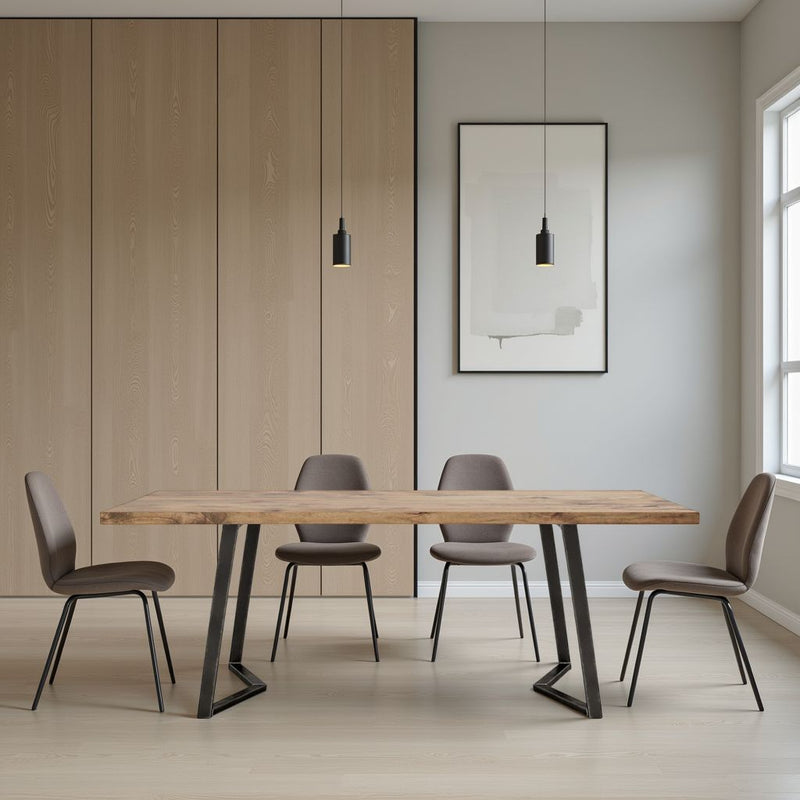 A modern dining room with the James+James Arkwright Dining Table in Harvest Wheat, four brown chairs, pendant lights, large wall art, light wood-paneled walls, and a bright window on the right.