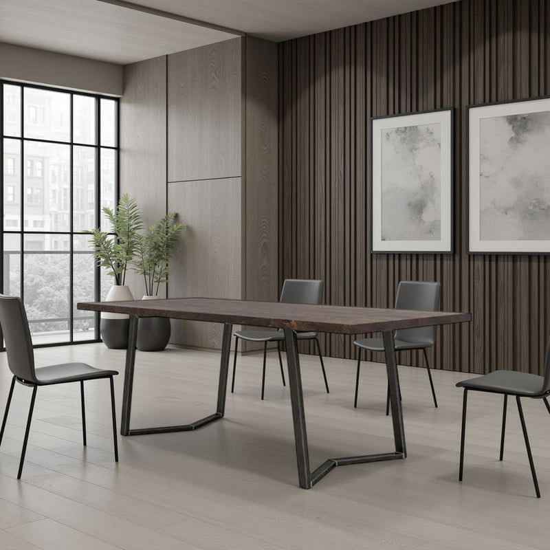 A minimalist meeting room features the James+James Arkwright Dining Table - Tobacco, four gray chairs, large windows, potted plants, and two abstract framed artworks on wood-paneled walls brightened by natural light.