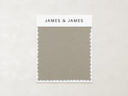 The Beige - Leather Swatch by James+James features a subtle, pebbled texture and zigzag-cut edges in muted taupe. Ideal for relaxed interiors, this soft Ultra Leather sample is labeled with the James+James brand at the top.