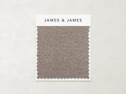 A textured taupe Stone - Boucle Swatch by James+James with zigzag edges is mounted on a white card labeled "James+James." The light beige background highlights this cozy, timeless fabric—ideal for inviting, textured interiors.