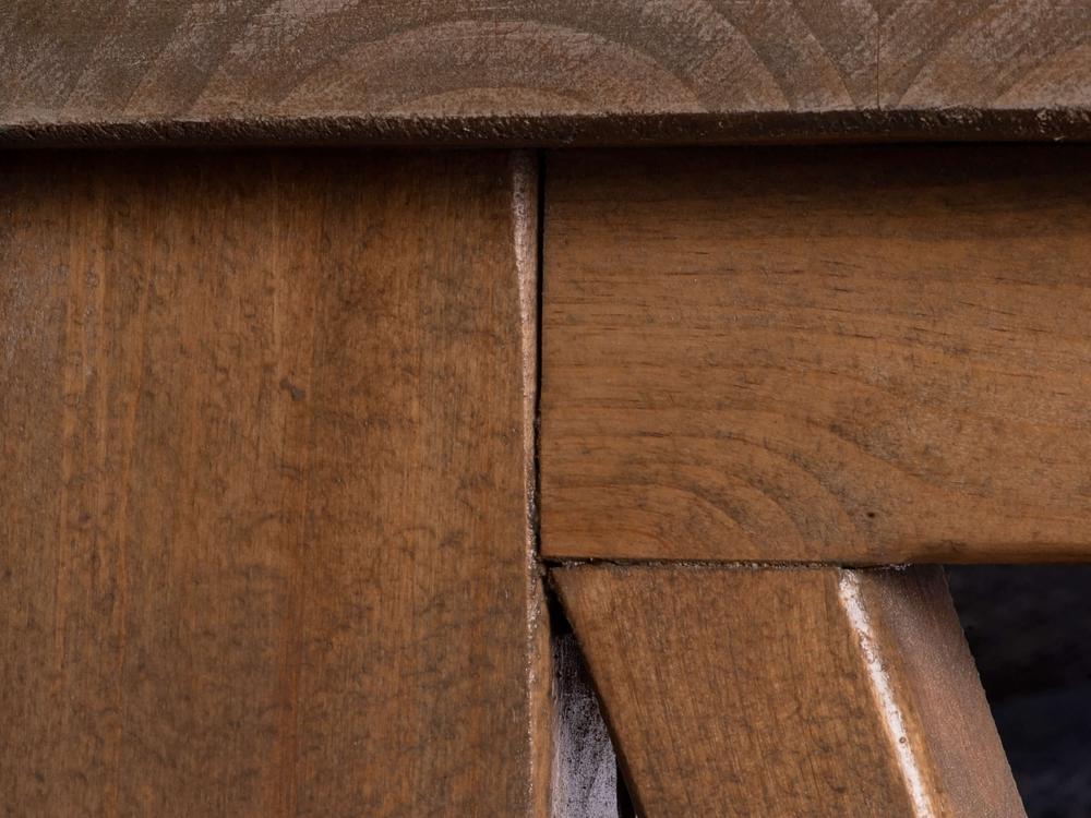 Close-up image of the Carter X Sofa Table - Harvest Wheat by James+James, showcasing a wooden furniture joint with two intersecting pieces of wood. The wood grain and texture are clearly visible, highlighting the craftsmanship of the joinery. The joint appears smooth and well-fitted, with a slightly rustic finish.