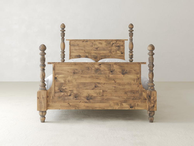 The Catherine Bed - Harvest Wheat by James+James is a rustic wooden bed showcasing a robust headboard and footboard with elegantly turned posts, set against a plain white background. The natural wood features visible knots and grain patterns, adding to its charm.