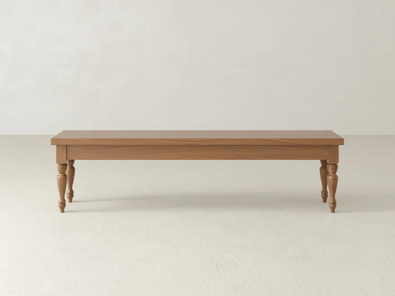 The Chateau Bench - Oat on Alder by James & James features a rectangular wooden seat and four turned legs, shown against a plain white wall and light-colored floor.