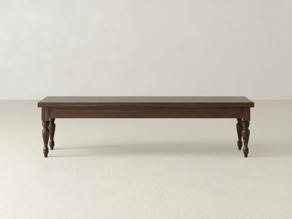 The James & James Chateau Bench - Sable on Oak features a dark rectangular top and four turned legs, set on a light-colored floor against a plain, light background.