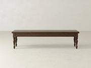 The James & James Chateau Bench - Sable on Oak features a dark rectangular top and four turned legs, set on a light-colored floor against a plain, light background.