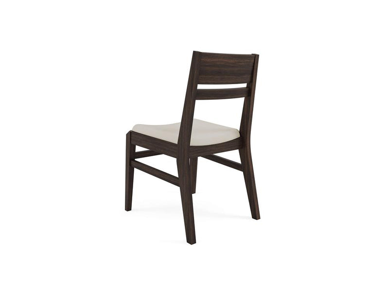 Wooden chair with a light padded seat, viewed from the back at an angle. The chair features a dark wooden frame with a simple, modern design and two horizontal slats on the backrest.