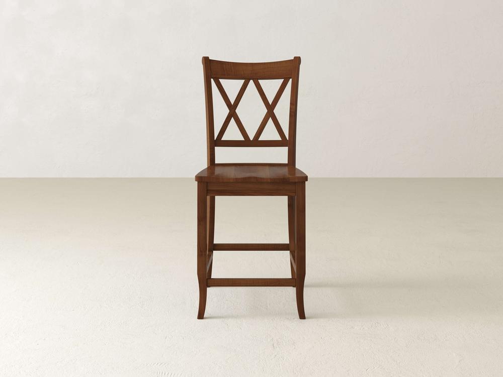 A James & James Double X Back Stool is set in an empty room, displaying timeless elegance against light-colored walls and flooring. Centered in the image, it exemplifies superior craftsmanship and classic style.
