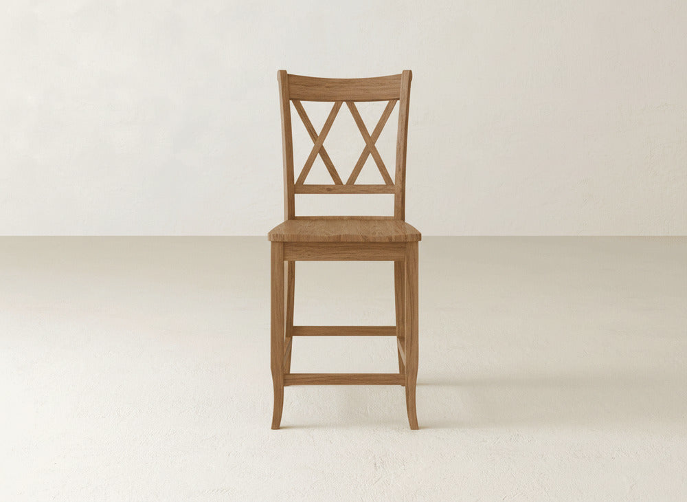 The James & James Double X Back Stool showcases a sturdy wooden build with an X-back design and straight legs, displayed on a light floor against an off-white wall.