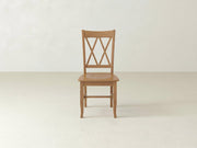 The James+James Double X-Back Dining Chair features a flat wooden seat and distinctive intersecting X-back design, adding timeless elegance to any space with its classic style.
