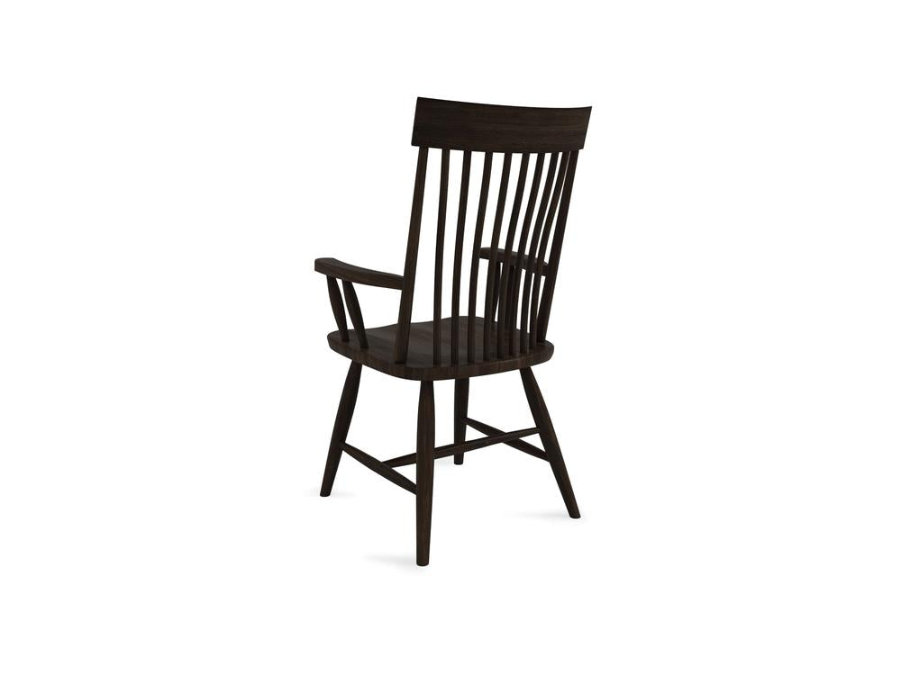 A dark wooden armchair with a high, vertical slatted back. The chair has curved armrests and a slightly angled seat. The design is simple and traditional, highlighting the natural wood grain.