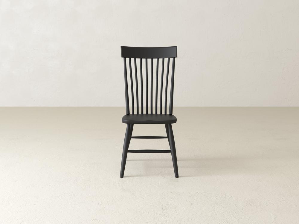 A wooden chair with a simple design, featuring a flat seat and a high backrest made of vertical slats, set against a plain white background.