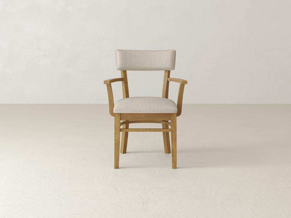 A wooden chair with armrests and light beige upholstered seat and backrest is centered against a plain white background. The design is simple and contemporary, showcasing clean lines and a minimalist aesthetic.