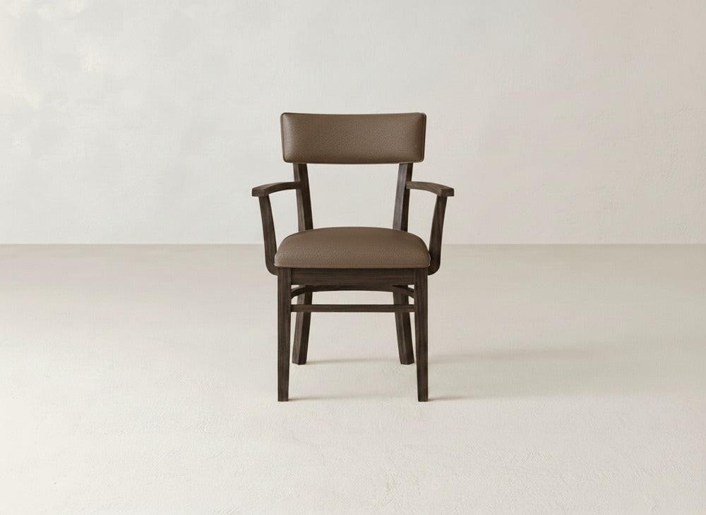 The Everly Arm Dining Chair by James+James features a brown wooden frame, cushioned seat, backrest, and armrests, shown centered against a plain, light-colored background.