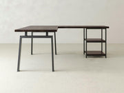 The Fulton Corner Desk by James & James features an L-shaped design with a tobacco wood finish and black metal frame, complemented by open shelving on one side and a spacious desktop.