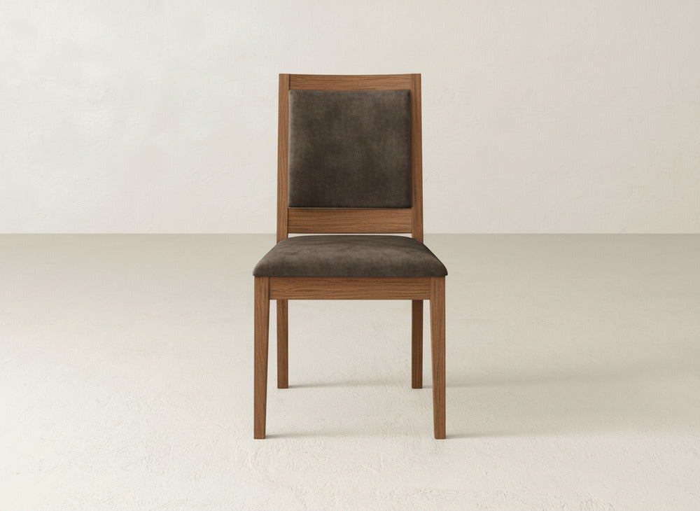 The James+James Gina Side Dining Chair has a brown padded seat and backrest made from maple wood, set on a light floor with a beige wall backdrop.