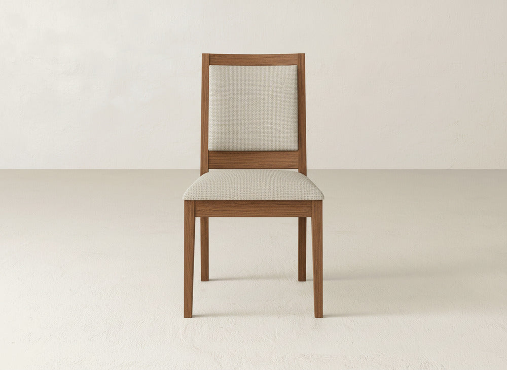 The Gina Side Dining Chair by James+James is a modern maple chair with a light beige upholstered seat and backrest, shown on a light-colored floor against an off-white wall.