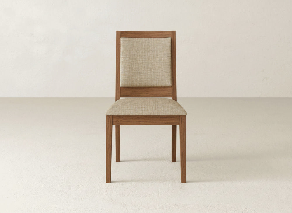 The Gina Side Dining Chair by James+James features maple wood construction with a beige upholstered seat and backrest, shown on a plain, light background.